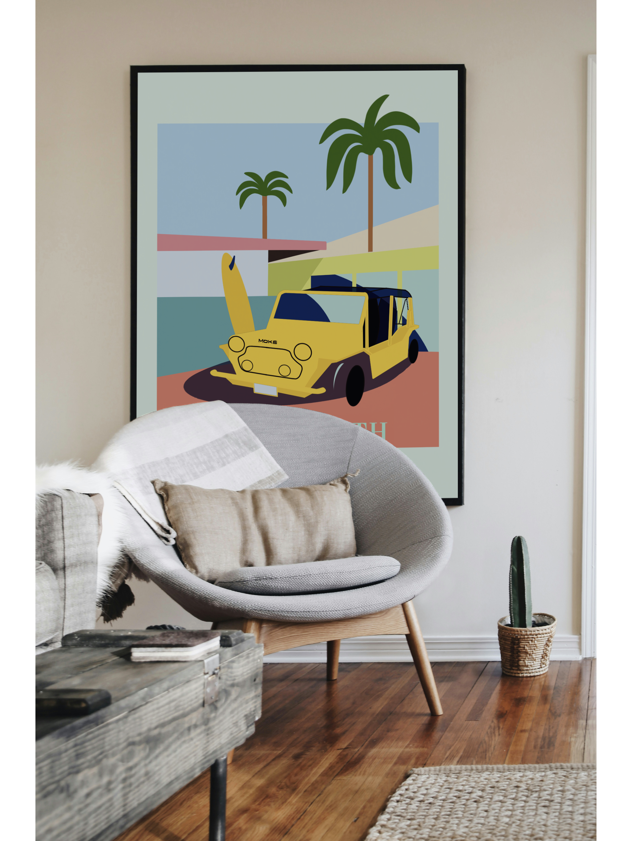 Mockup intérieur mettant en scène une affiche encadrée représentant une illustration graphique de Saint-Barth avec une voiture Moke jaune et des palmiers. L’affiche est posée sur un mur beige dans un salon élégant, avec un fauteuil design gris clair, un coussin en lin, une table basse en bois brut, et une touche végétale avec un petit cactus.